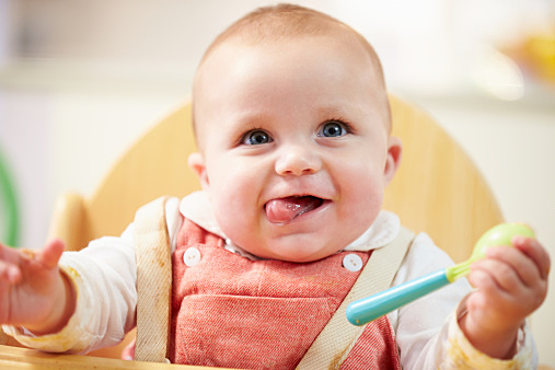 Portrait Of Happy Young Baby Boy In High Chair