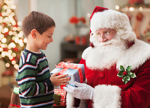 Santa giving Caucasian boy Christmas gift